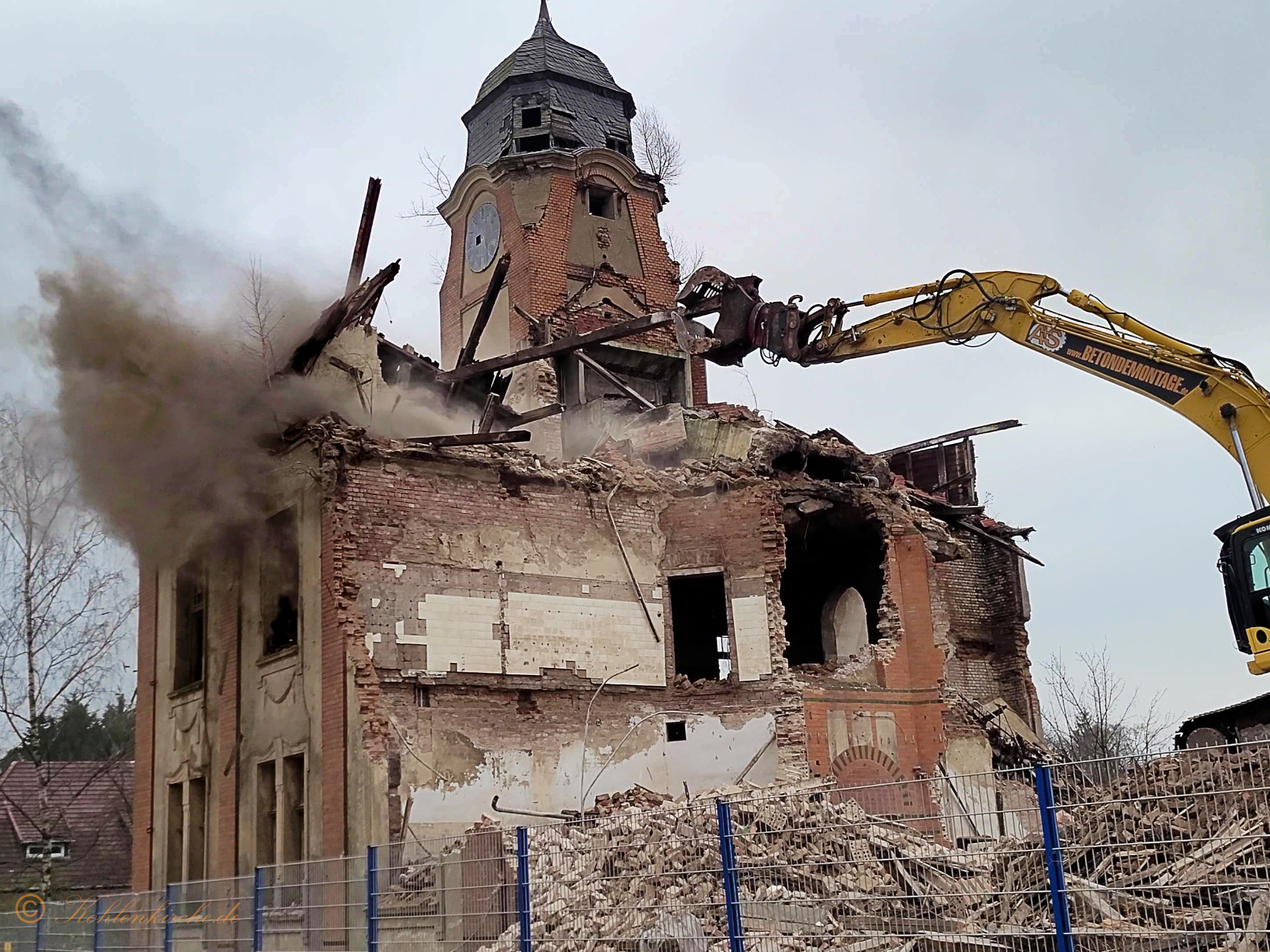 Mit einer langen Holzlatte, die von der Kohlenkirche stammt, bohrt der Fahrer des Abrissbaggers in die Wände der Kohlenkirche und bringt das Dach zum Einstürzen. - 18.12.2023 Kohlenkirche: Der Abriss der Kohlenkirche